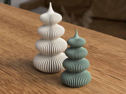 Two ceramic towers, one white and one green, on a wooden surface.