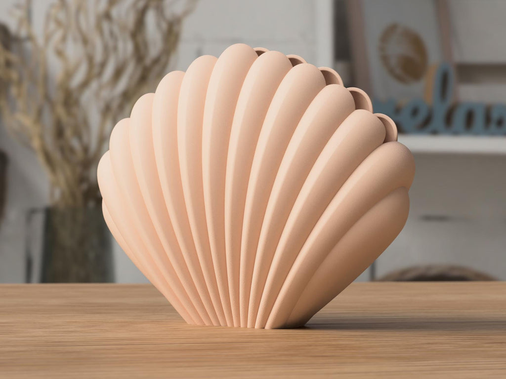Shell-shaped decorative vase on a wooden surface with a blurred indoor background