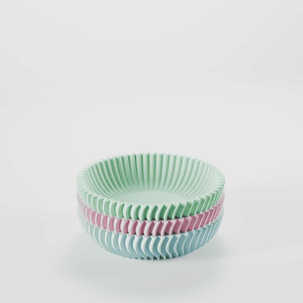 Stack of green and pink ribbed bowls on a white background