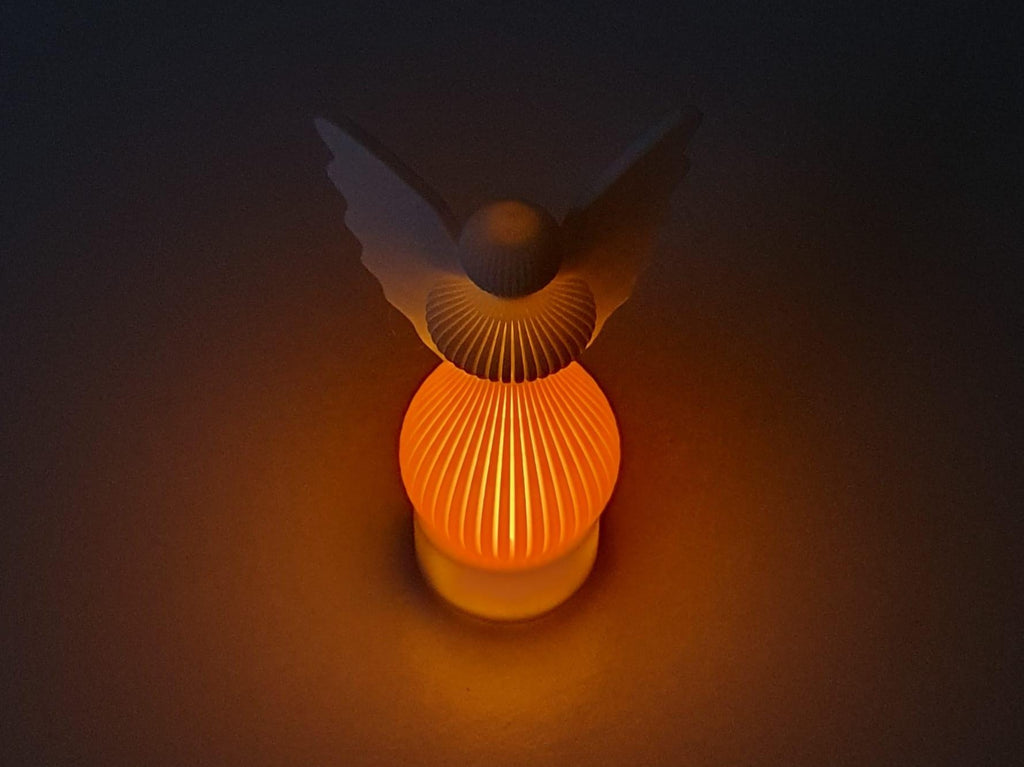 Decorative lamp with a bird-shaped shade on a dark background
