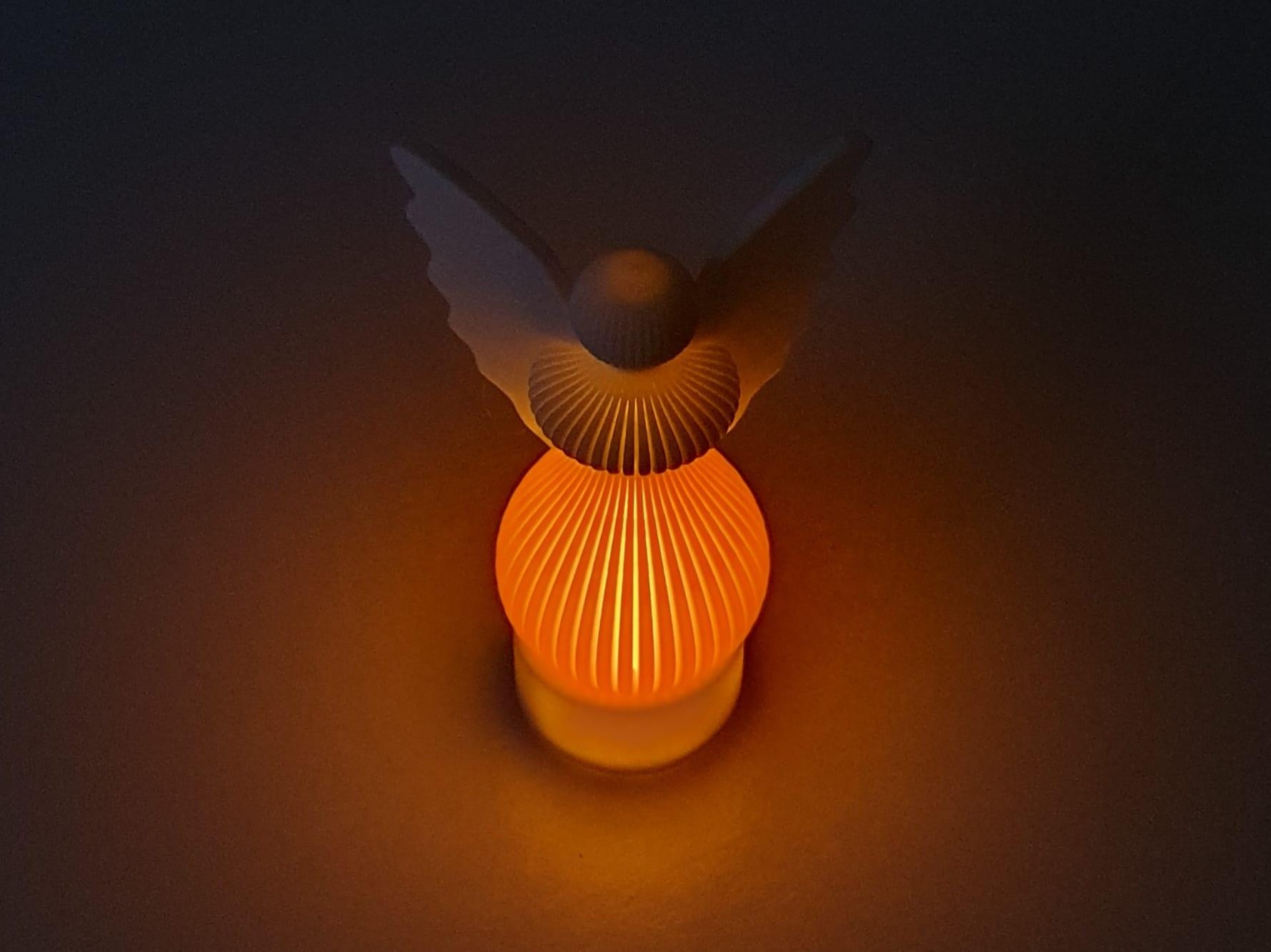 Decorative lamp with a bird-shaped shade on a dark background
