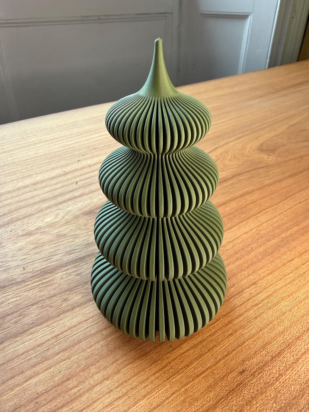 Green textured vase on a wooden surface