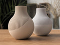 Two ceramic vases with textured design on a wooden surface