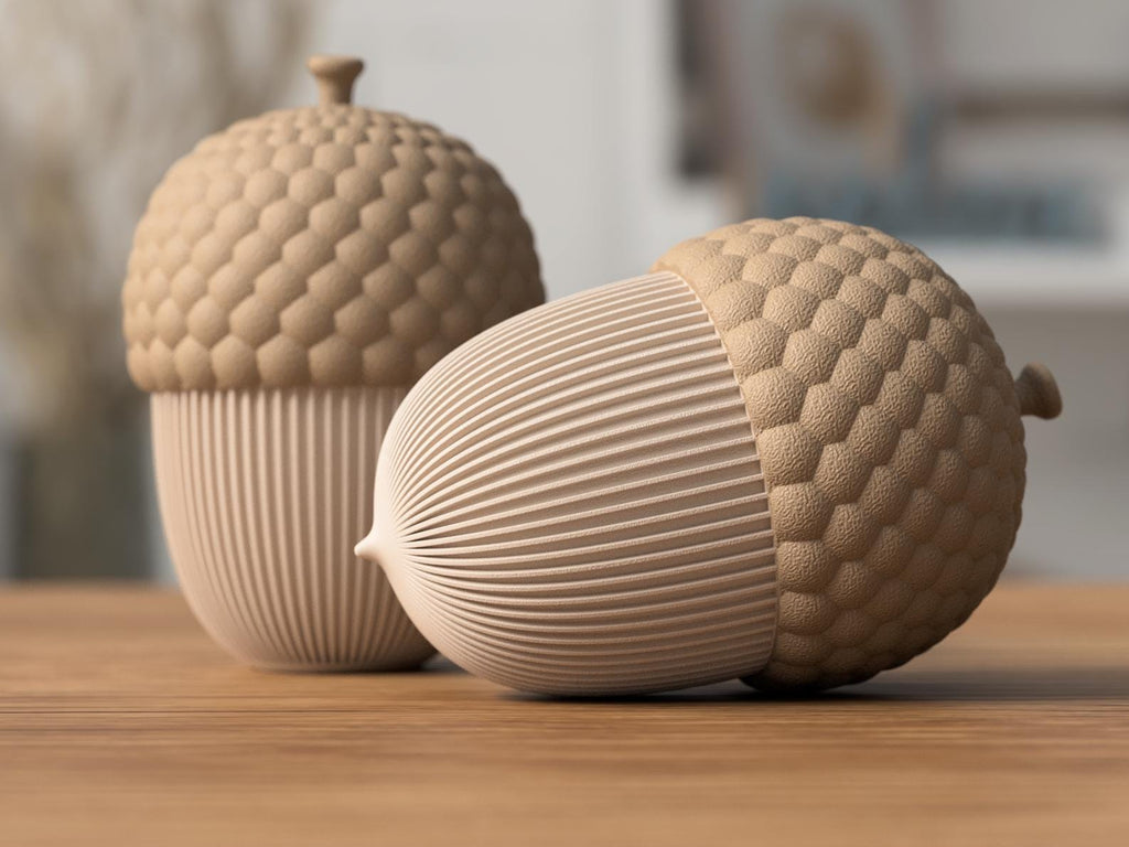 Two ceramic acorn-shaped containers on a wooden surface with a blurred background