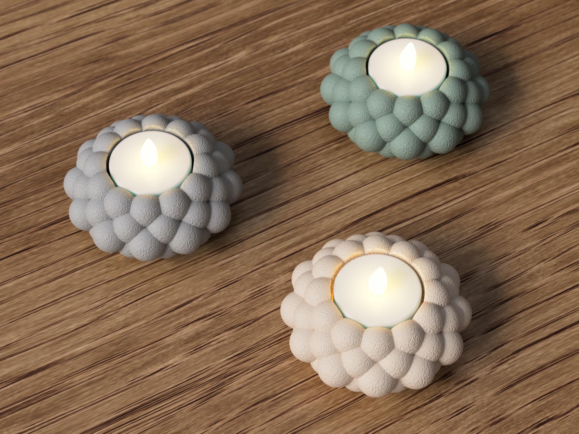 Three decorative candle holders with candles on a wooden surface