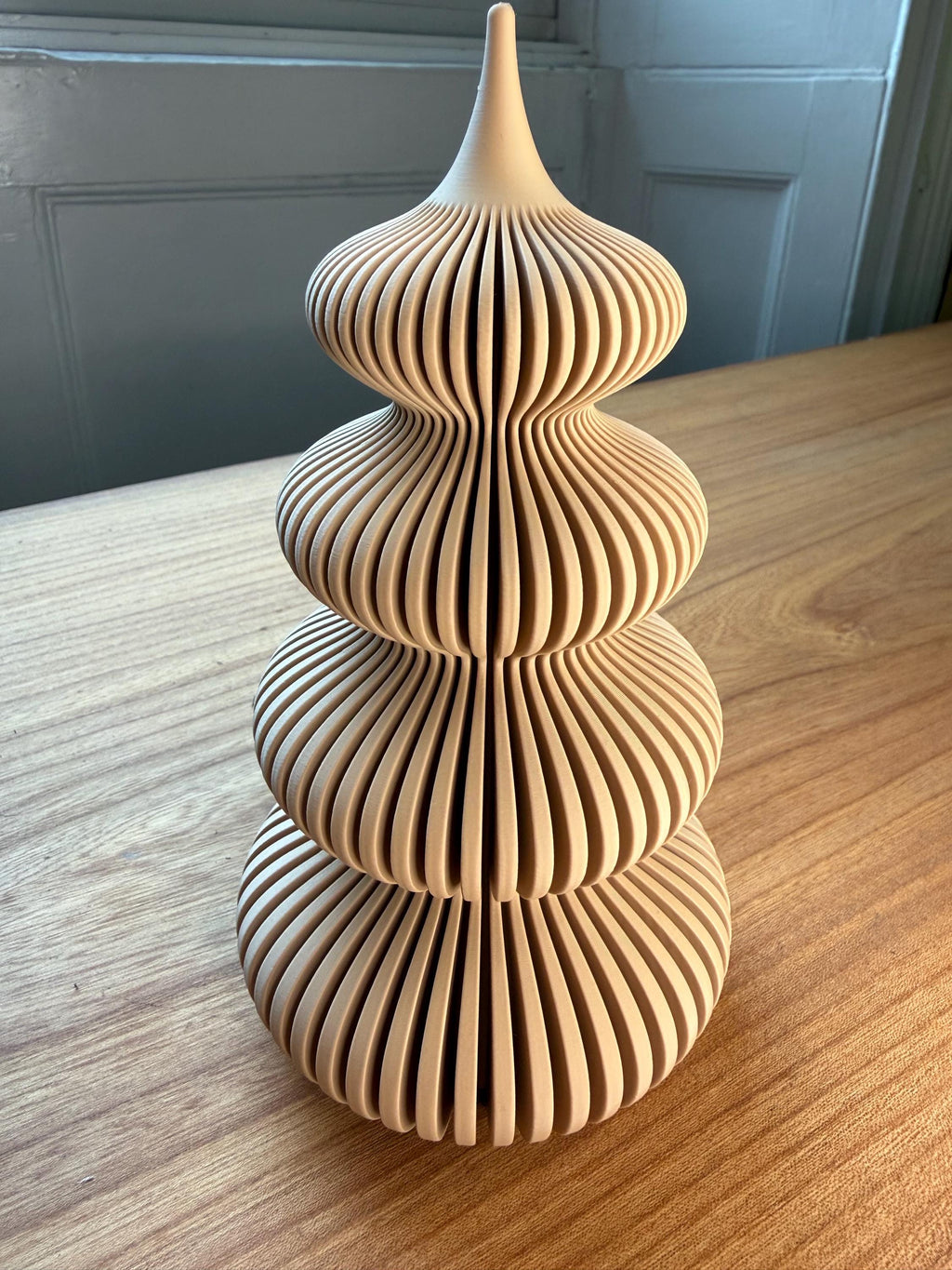Wooden decorative tower on a wooden surface with a neutral background