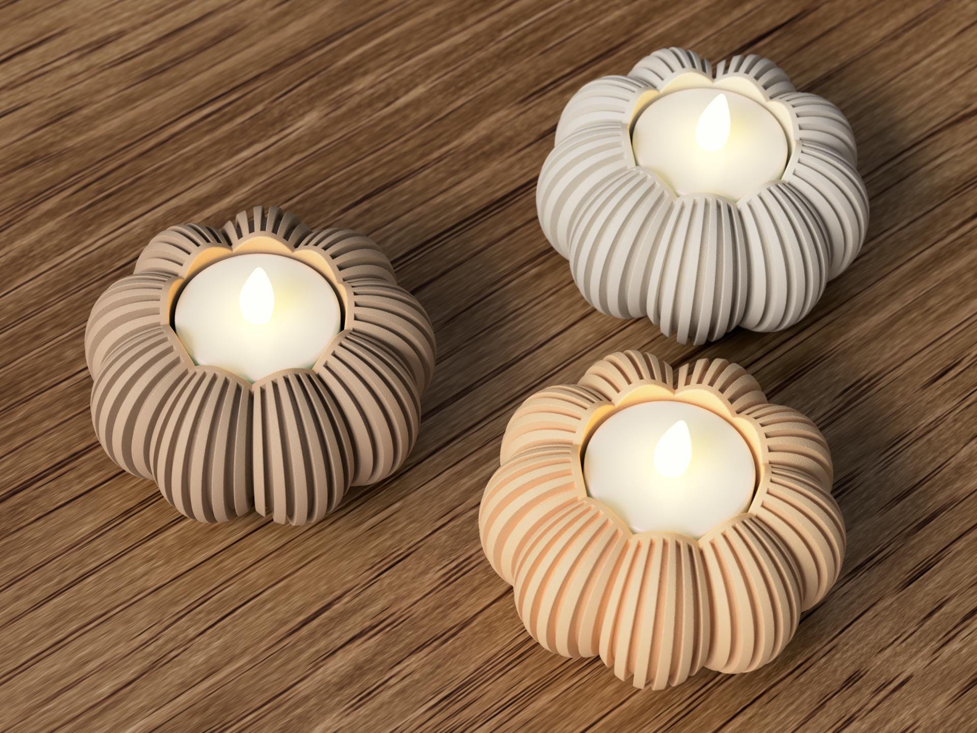 Three ribbed candle holders with lit candles on a wooden surface