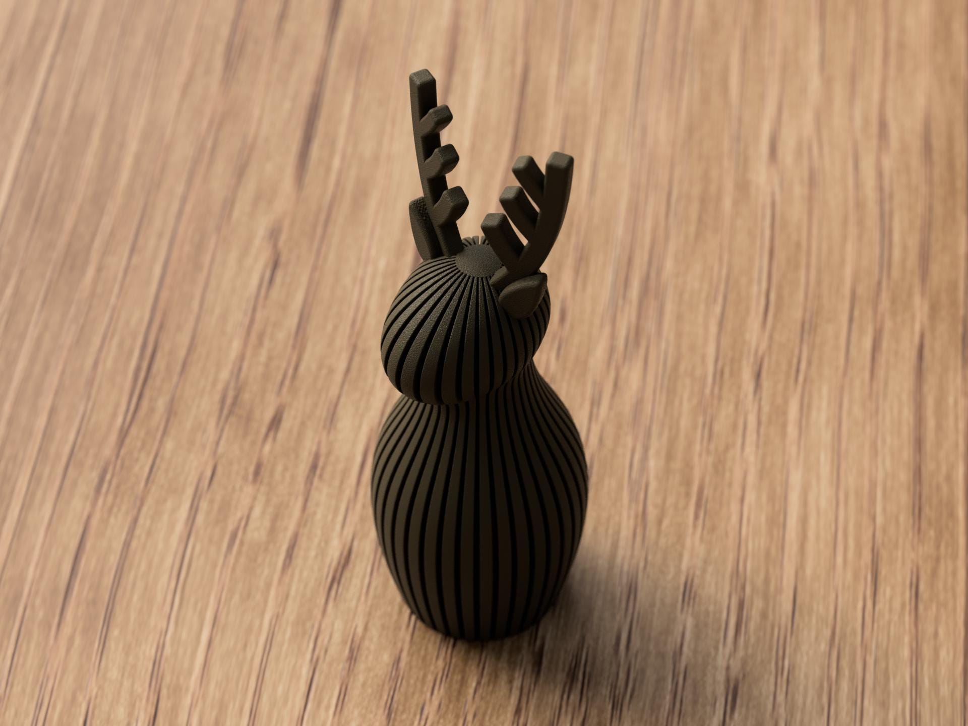 Black decorative object resembling a deer head on a wooden surface