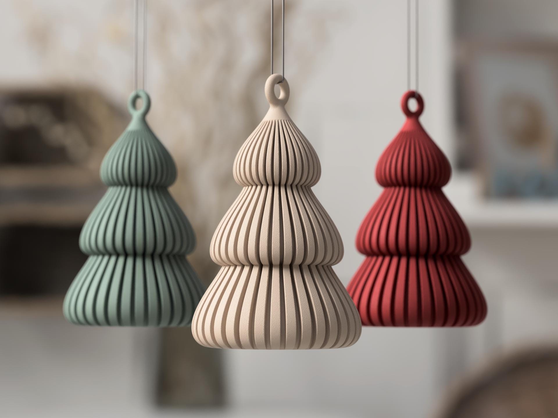 Three textured pendant lights in green, beige, and red hanging against a blurred indoor background.