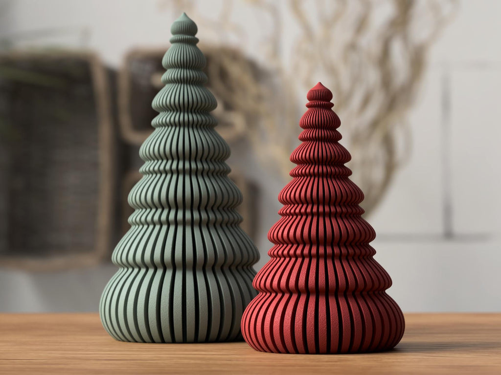 Two decorative trees, one green and one red, on a wooden surface with a blurred background.