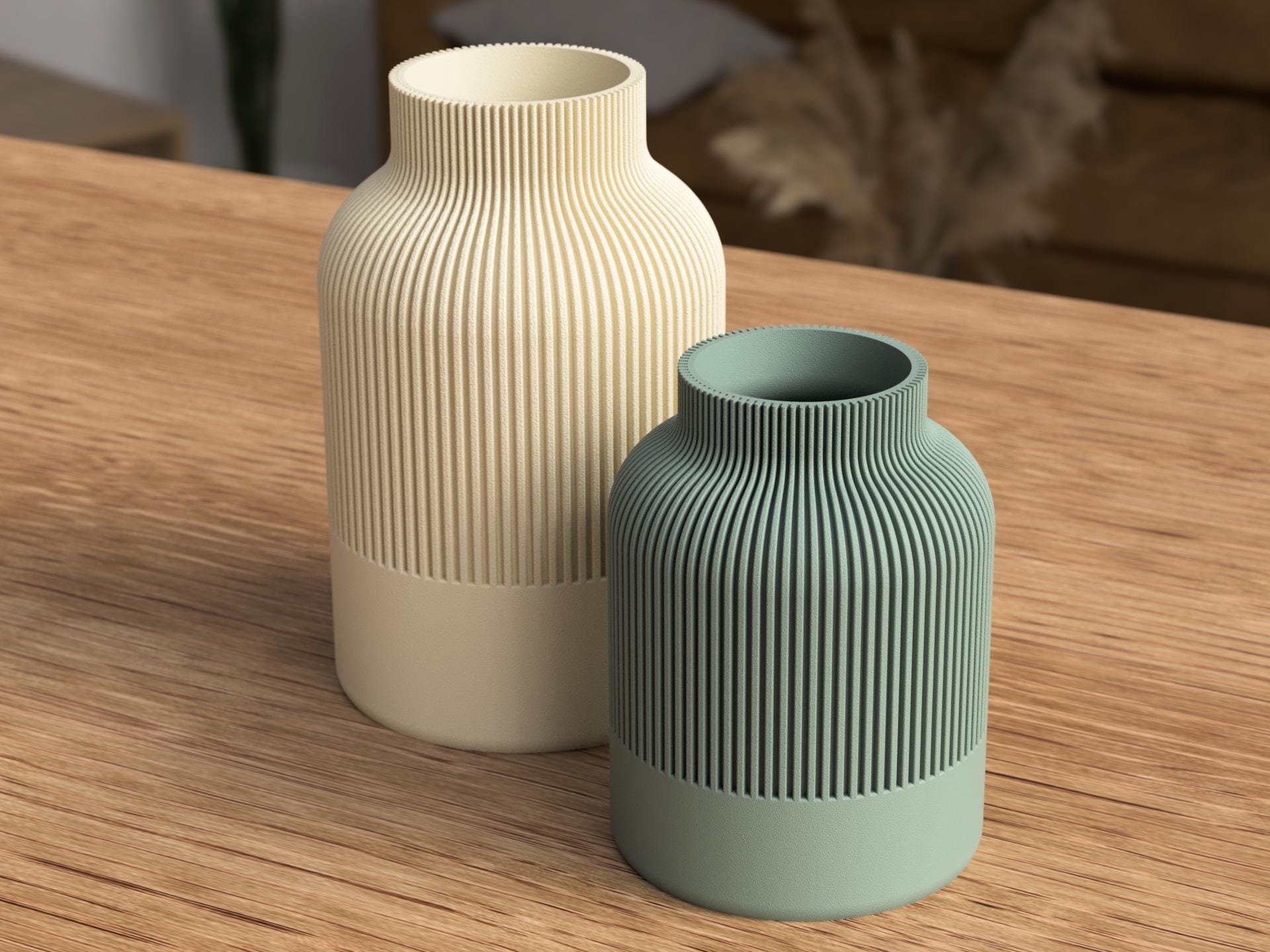 Two ceramic vases, one beige and one green, on a wooden surface.