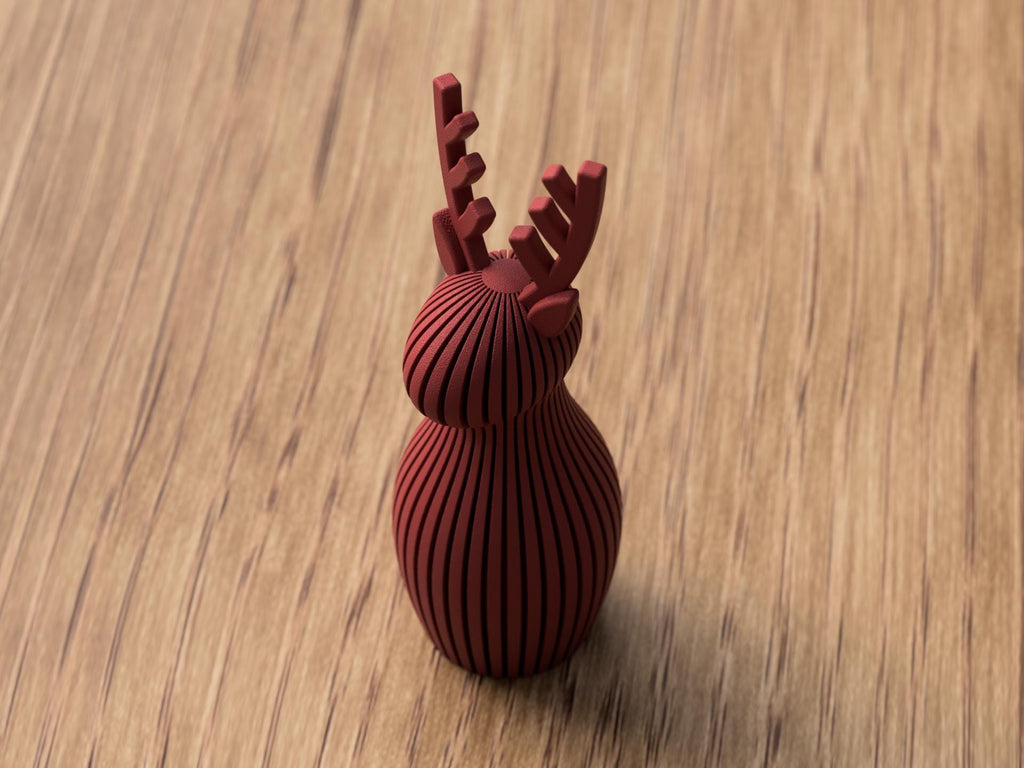 Red decorative object shaped like a reindeer on a wooden surface
