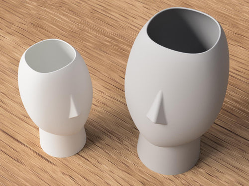 Two white ceramic vases with unique designs on a wooden surface