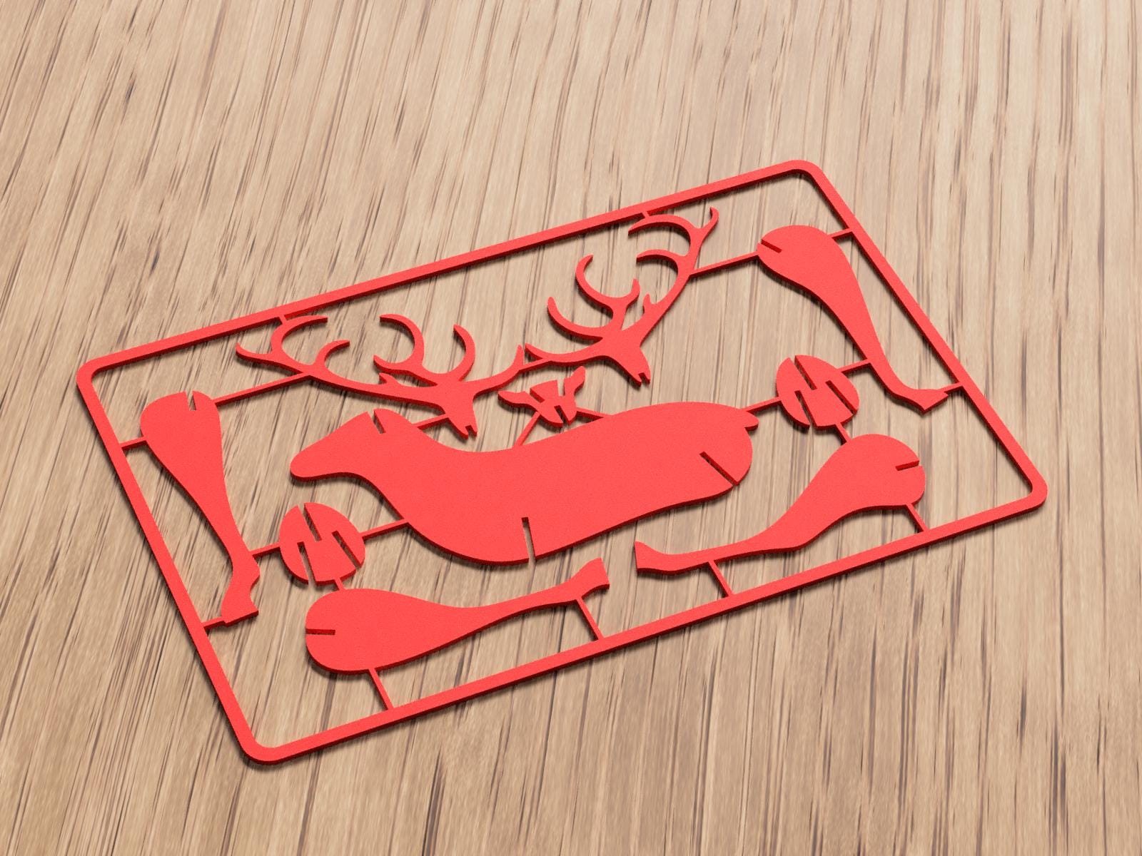 Red decorative cutout of a deer on a wooden surface