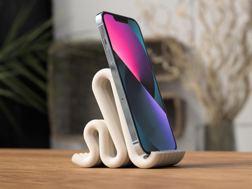 Phone on a white ceramic stand with a blurred background