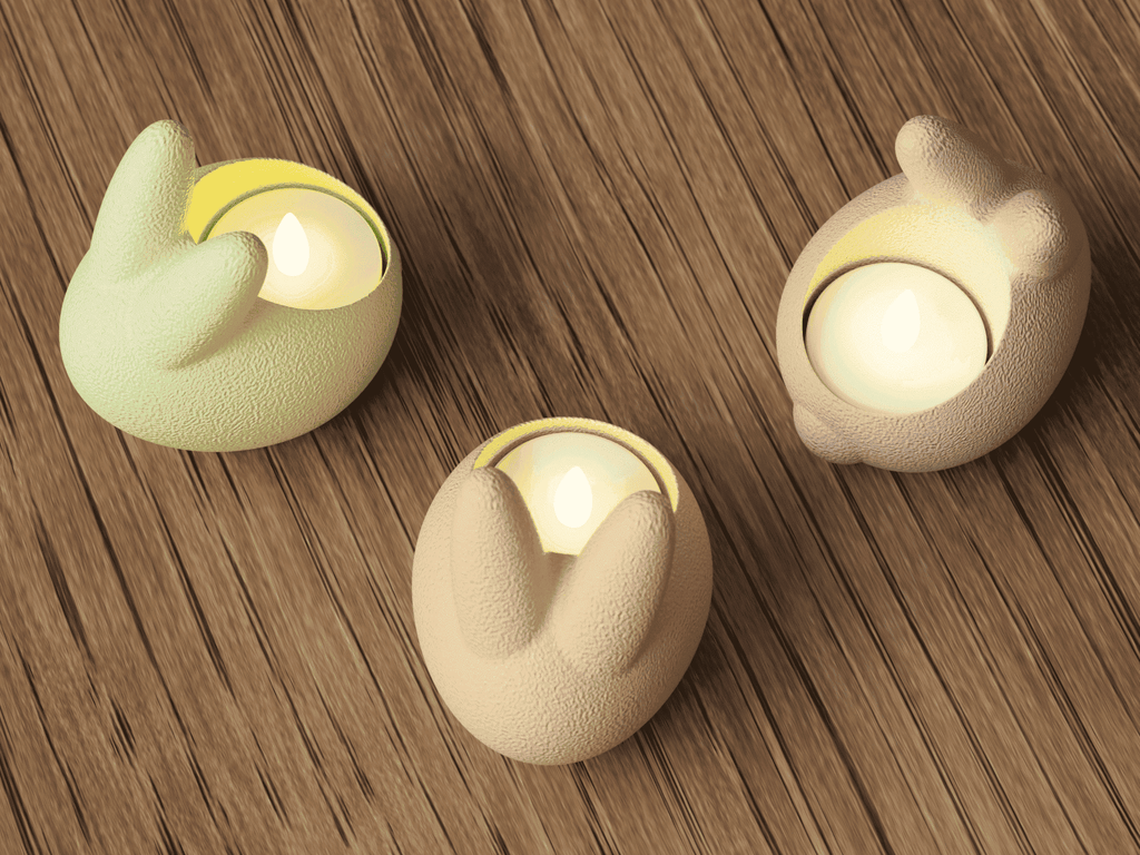 Three decorative candle holders shaped like animal ears on a wooden surface.