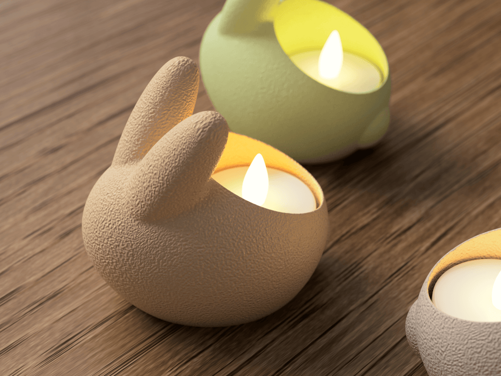 Three ceramic candle holders shaped like animals on a wooden surface.