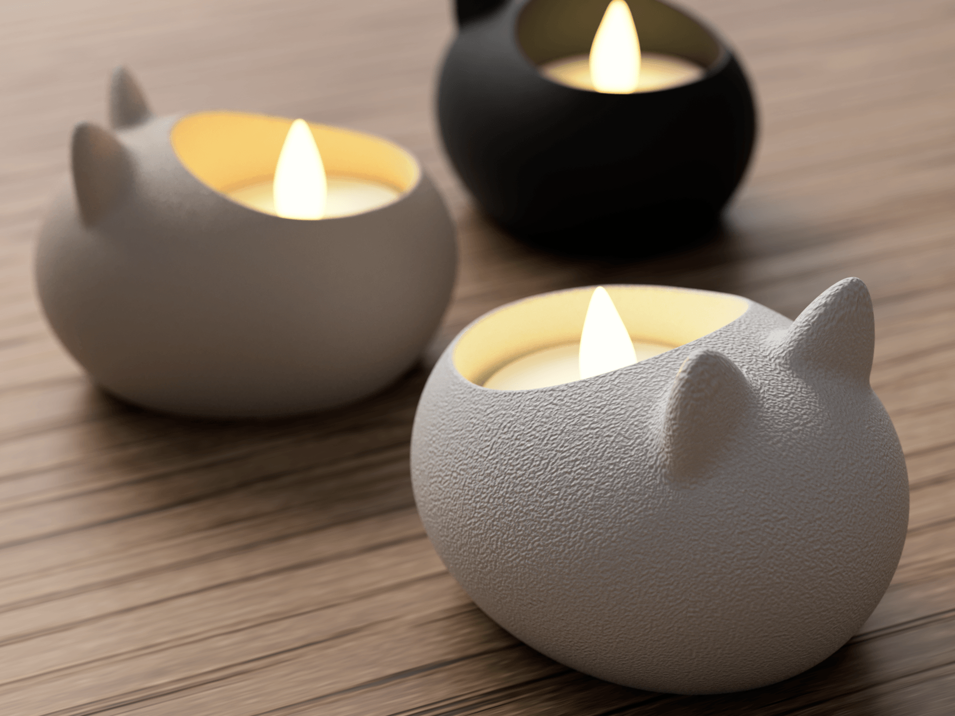 Three cat-shaped candle holders with lit candles on a wooden surface