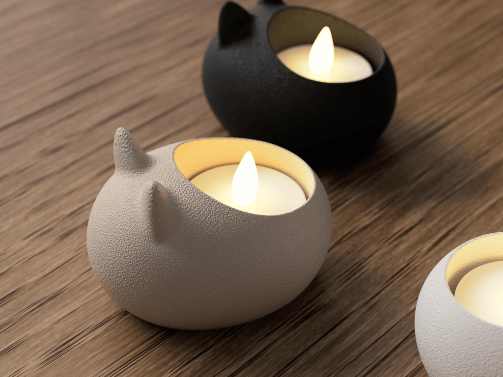 Two cat-shaped candle holders with lit candles on a wooden surface