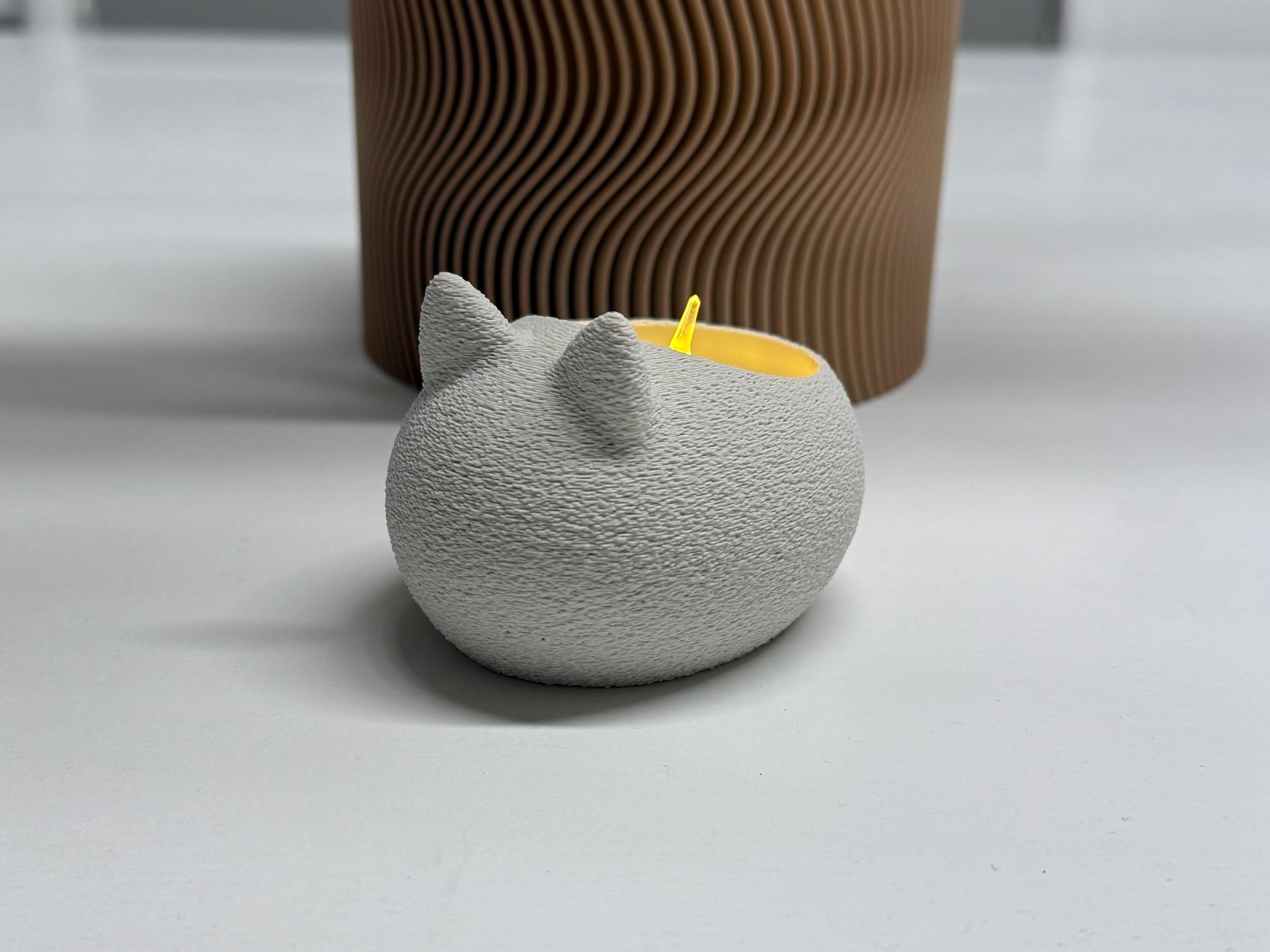 Gray cat-shaped container with a yellow interior on a light gray surface.