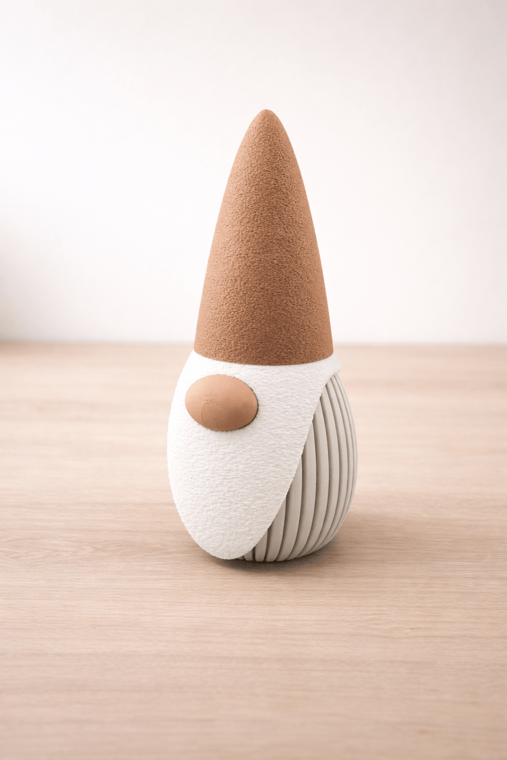 Decorative gnome with a brown hat and white body on a wooden surface