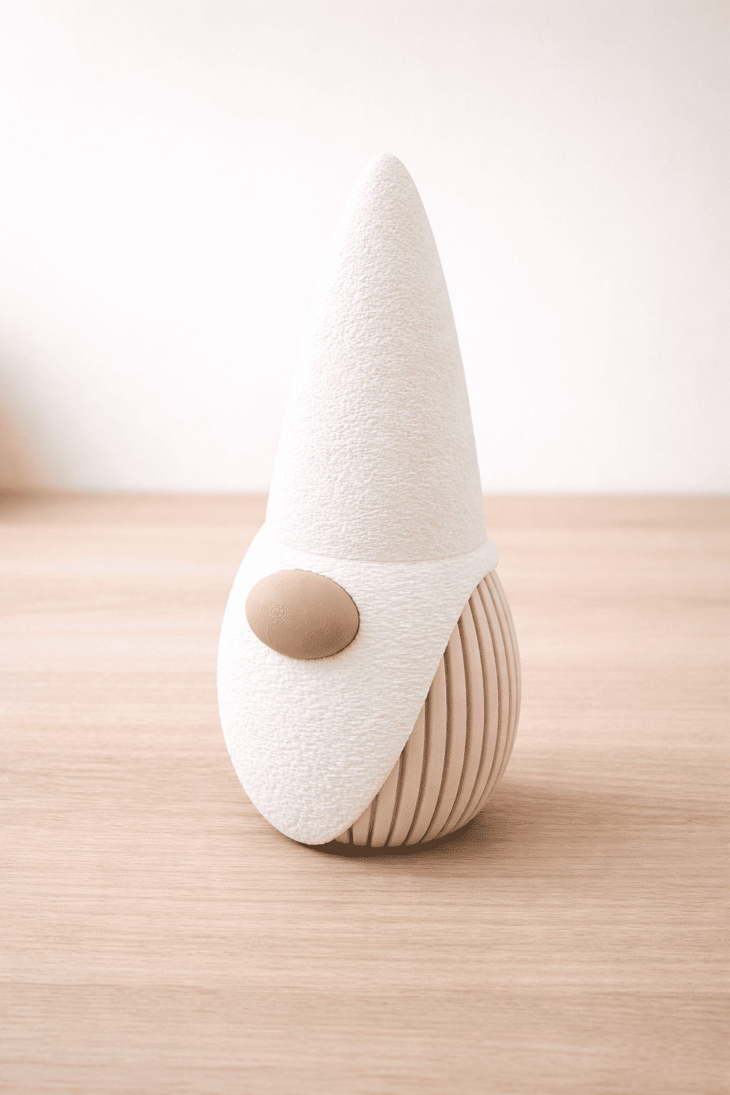 White gnome figurine with a brown button on a wooden surface