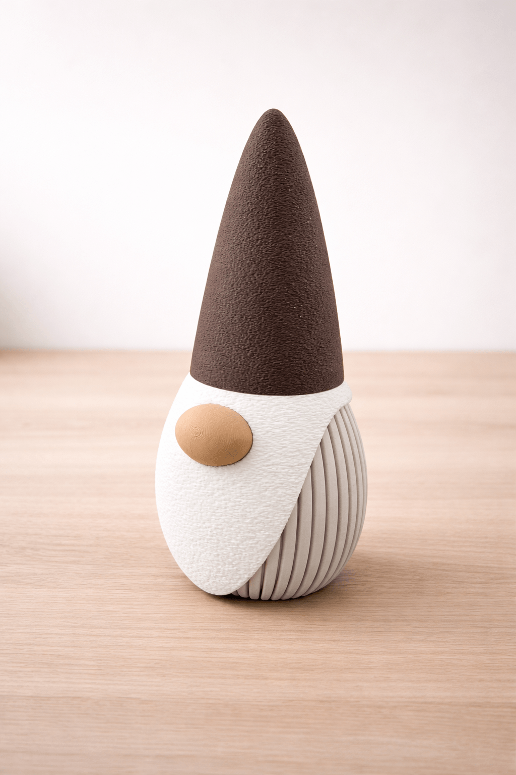 Small gnome figurine with a brown hat and white body on a wooden surface