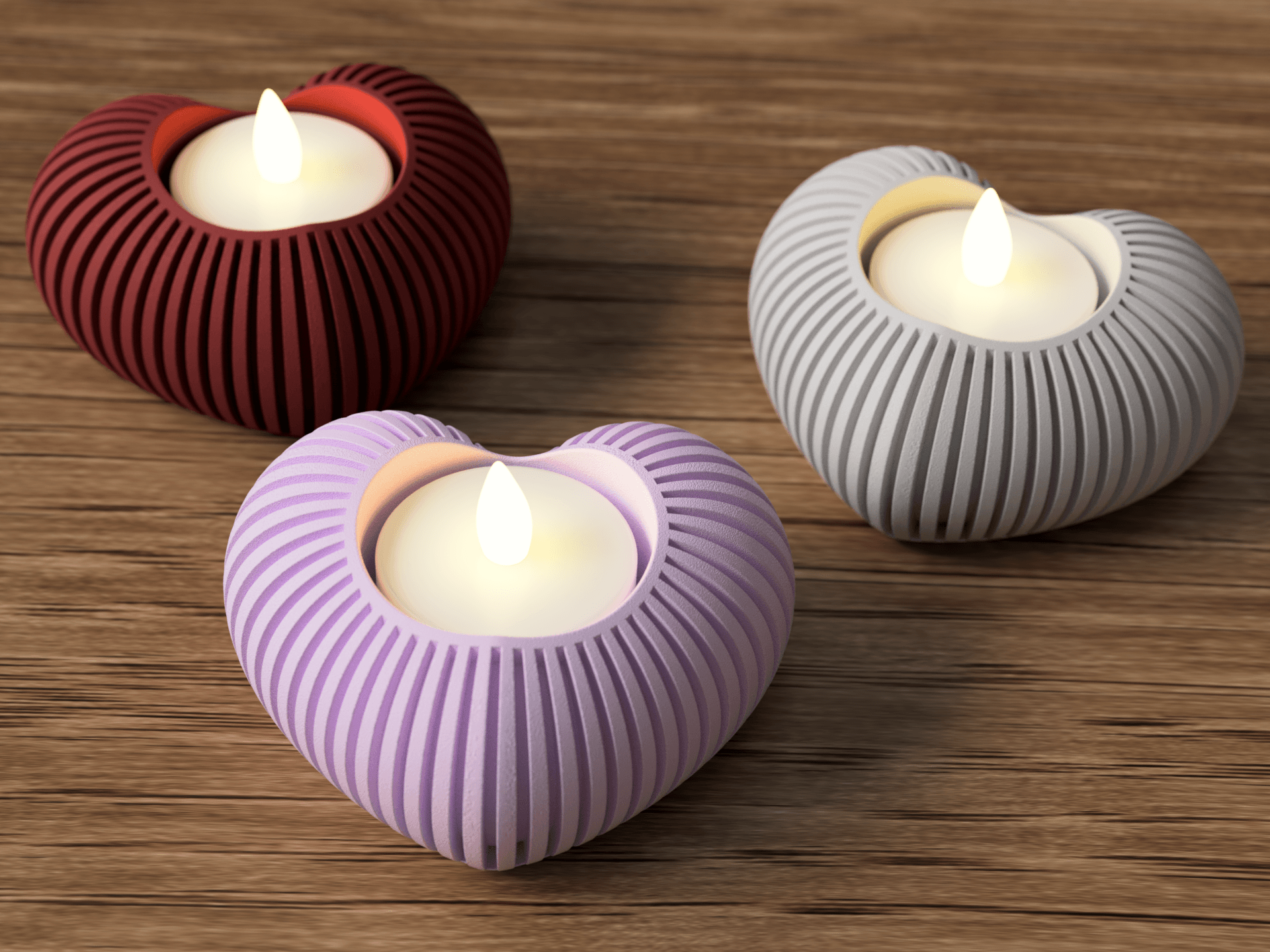 Three ribbed candle holders in red, purple, and gray with lit candles on a wooden surface.