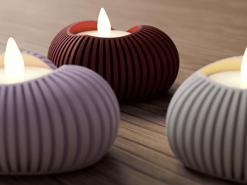 Three ribbed candle holders with lit candles on a wooden surface.