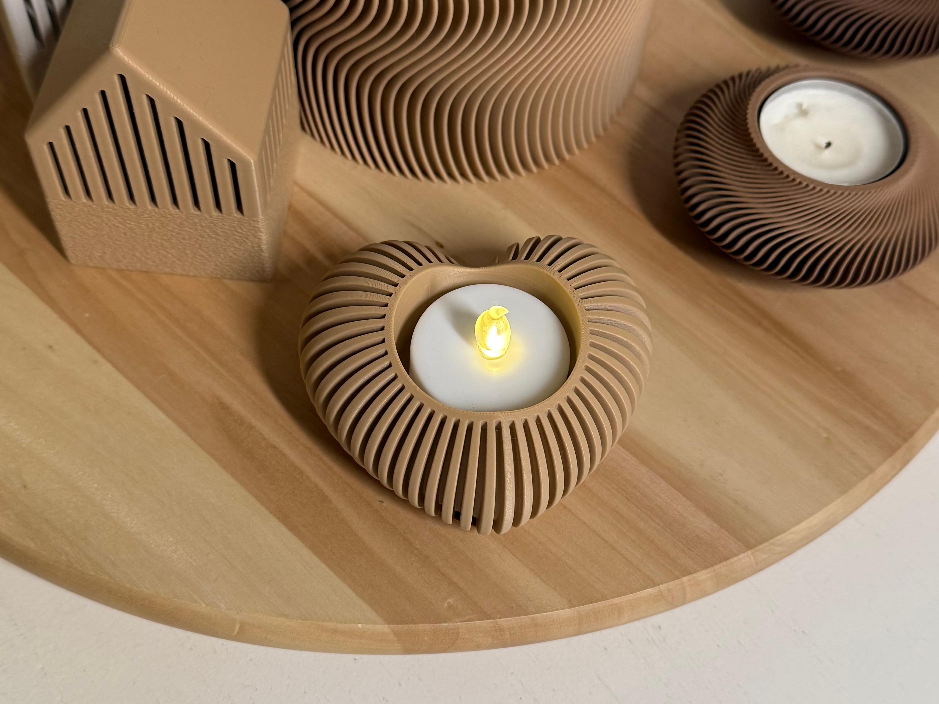Wooden candle holders with a lit candle on a wooden surface