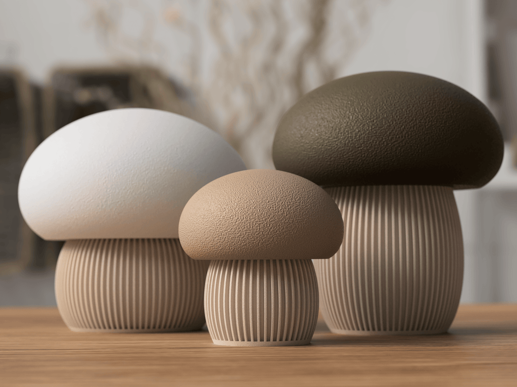 Three ceramic mushroom-shaped objects on a wooden surface with a blurred background