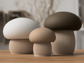 Three ceramic mushroom-shaped objects on a wooden surface with a blurred background