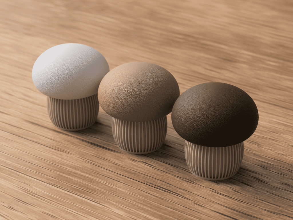 Three mushroom-shaped objects in white, beige, and green on a wooden surface