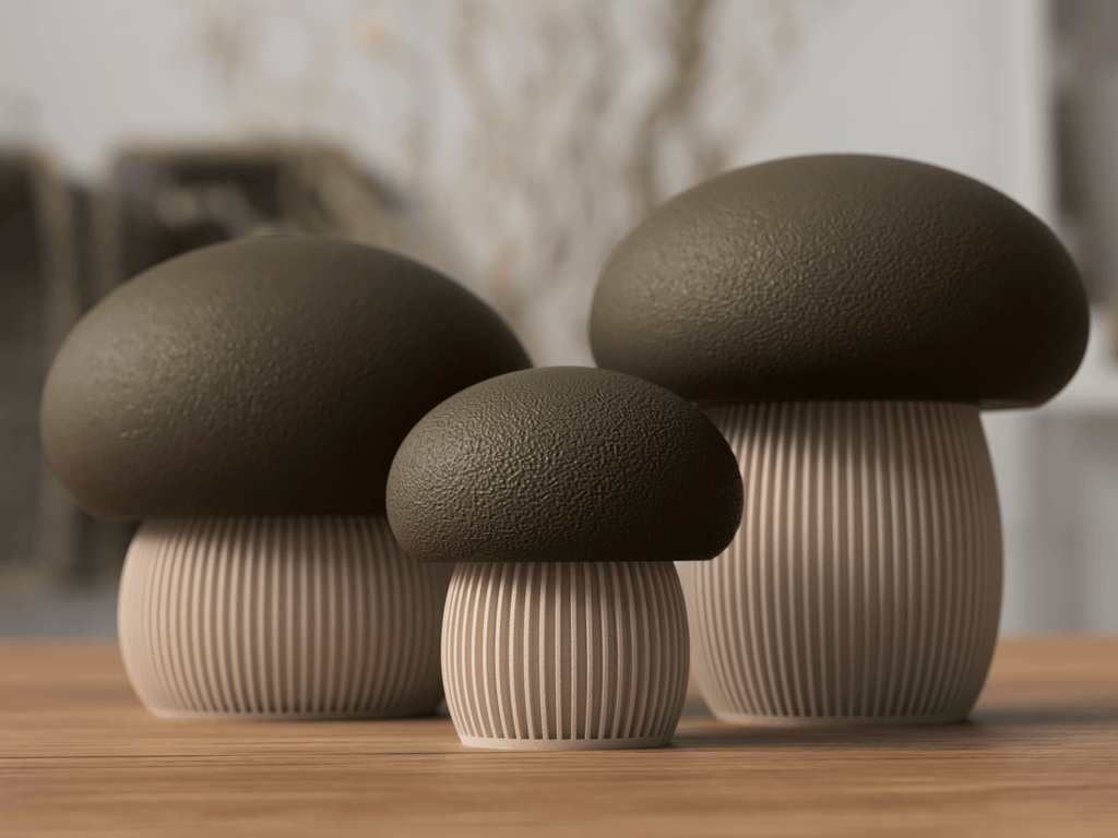 Three mushroom-shaped decorative items on a wooden surface with a blurred background