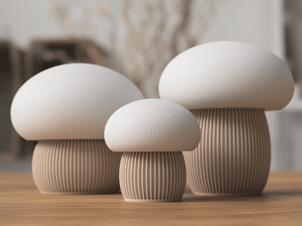 Three ceramic mushroom sculptures on a wooden surface with a blurred background