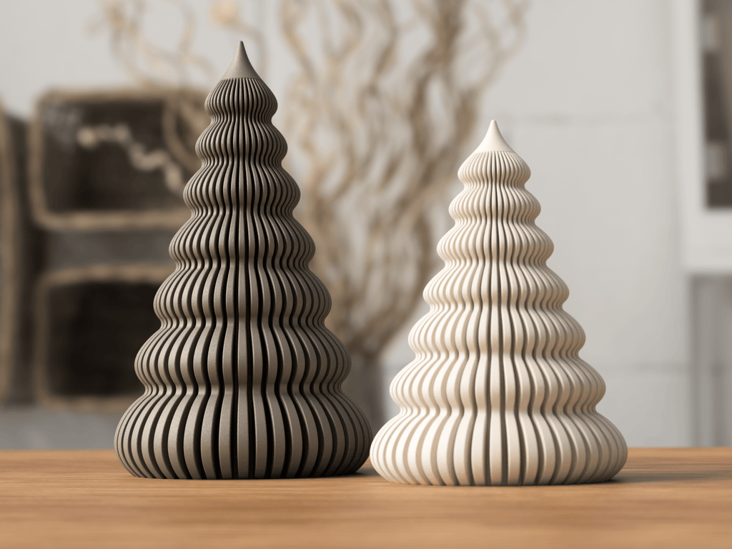 Two decorative Christmas trees made of wood on a wooden surface with a blurred indoor background.