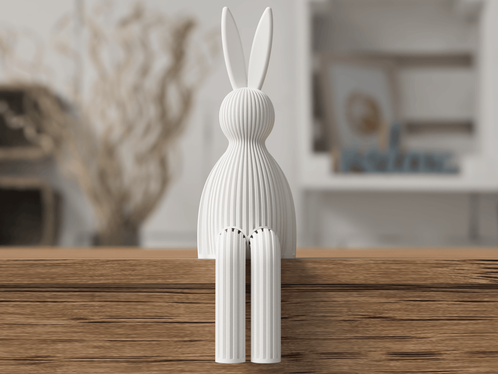 White rabbit-shaped decorative object on a wooden surface with a blurred indoor background