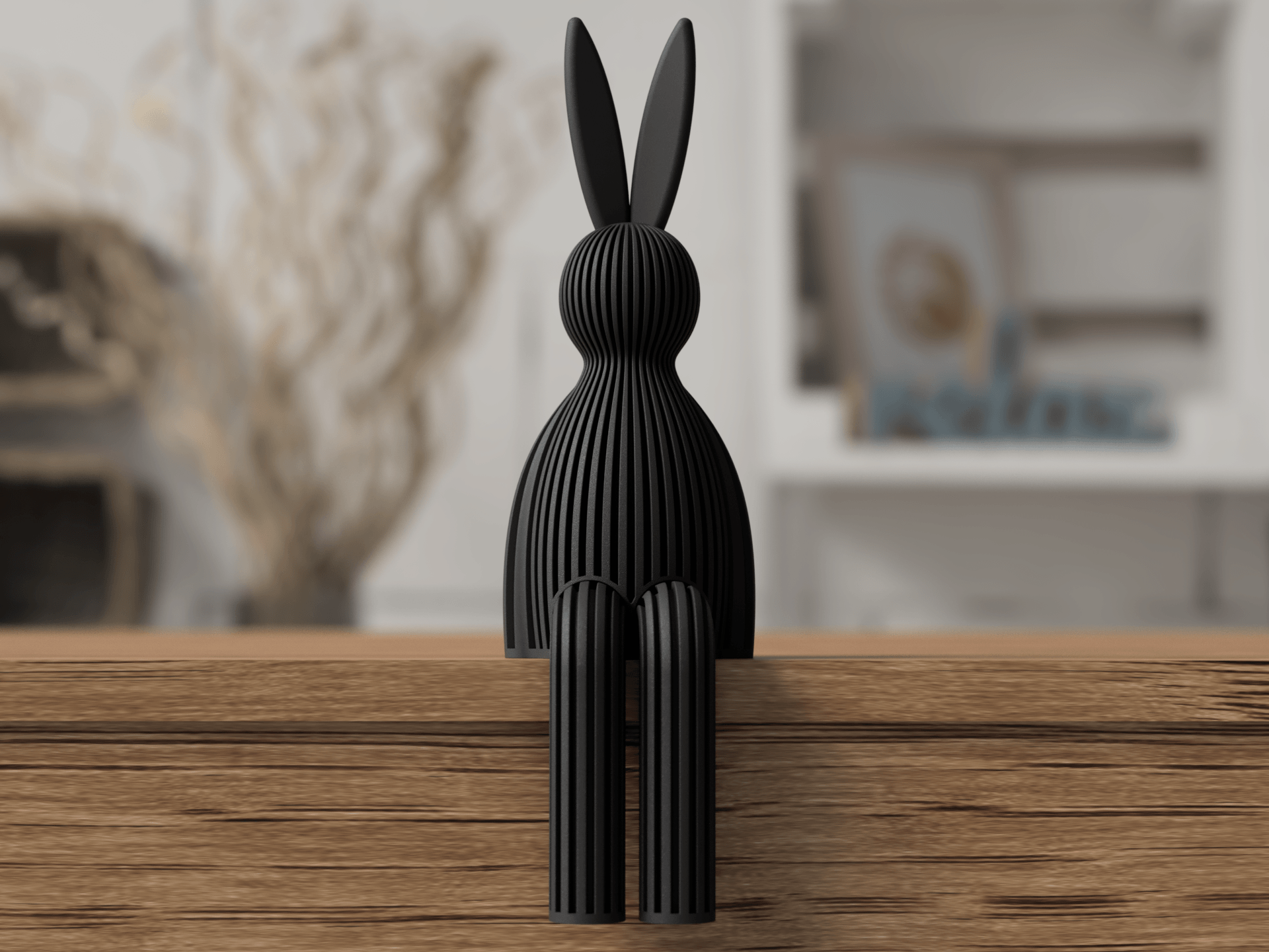 Black rabbit-shaped decorative object on a wooden surface with a blurred indoor background