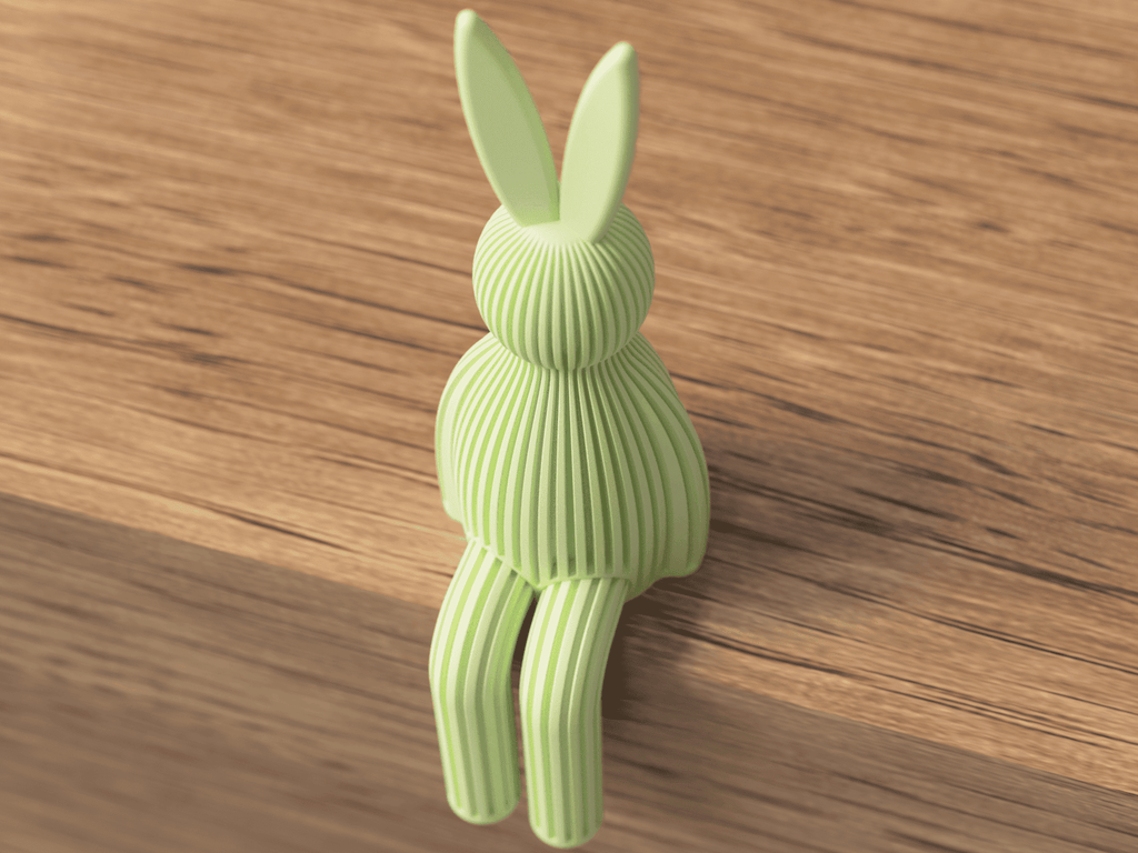 Green rabbit-shaped object on a wooden surface