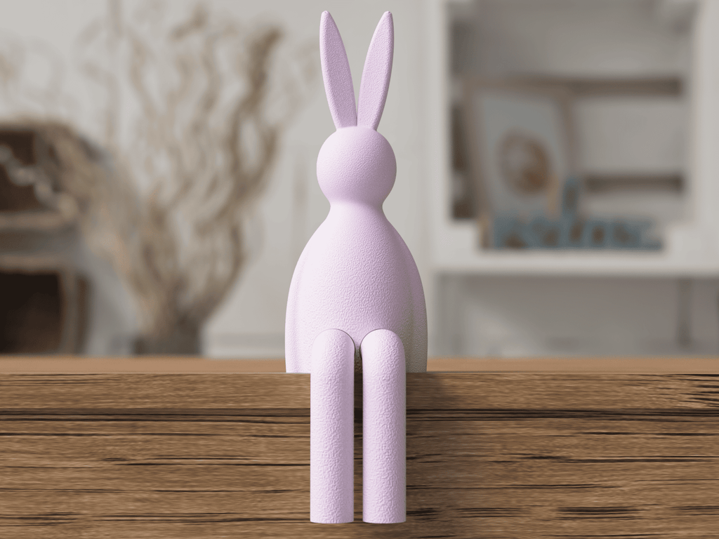 Purple rabbit-shaped object on a wooden surface with a blurred indoor background