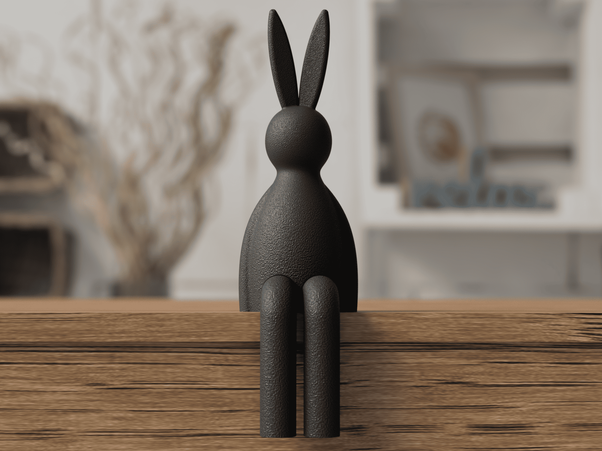 Black rabbit sculpture on a wooden surface with a blurred indoor background