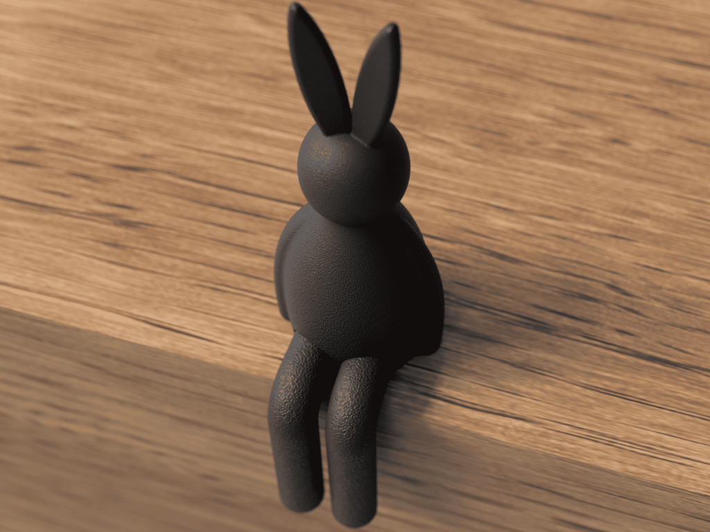 Black rabbit-shaped object on a wooden surface