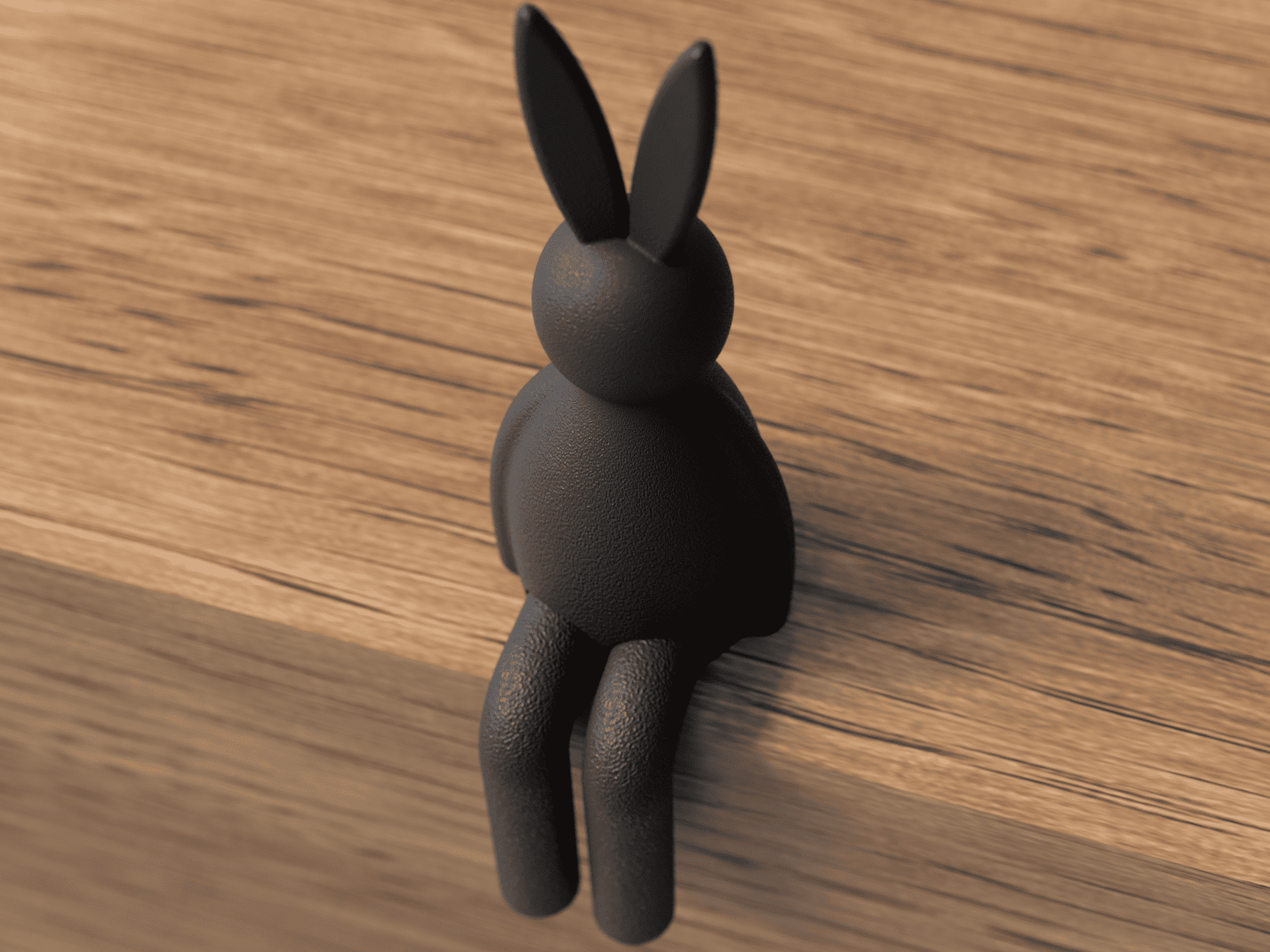 Black rabbit-shaped object on a wooden surface