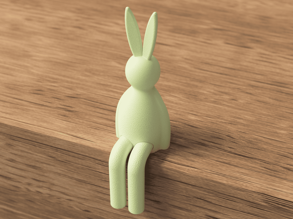 Green rabbit-shaped hook on a wooden surface