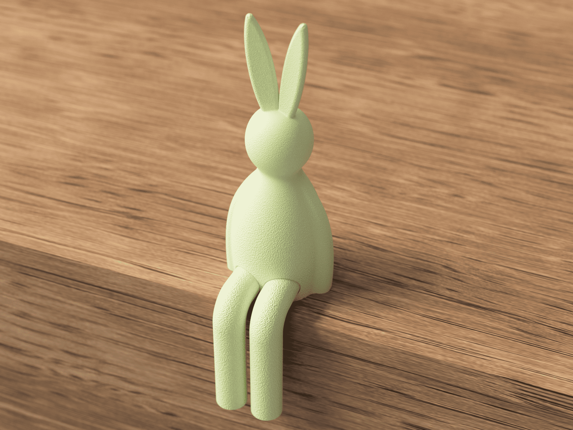Green rabbit-shaped hook on a wooden surface