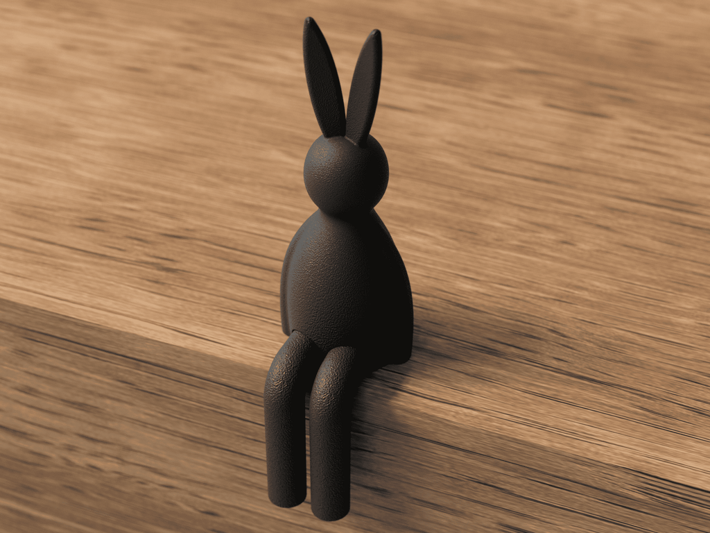 Black rabbit-shaped hook on a wooden surface