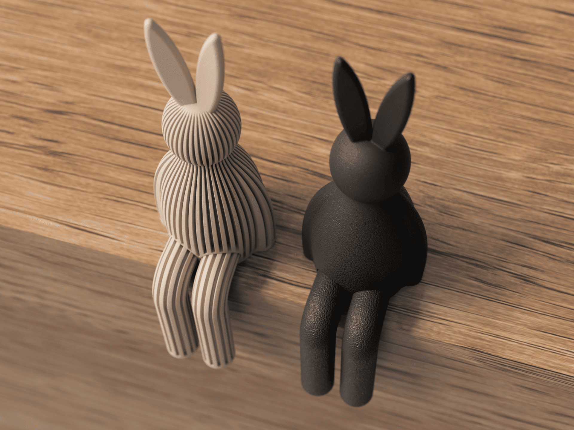 Two rabbit-shaped objects, one beige and one black, on a wooden surface.