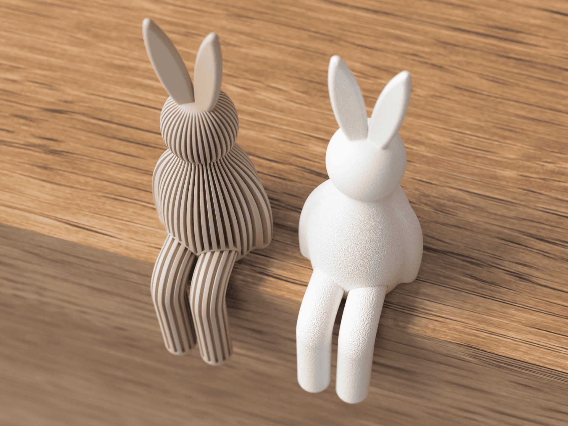 Two rabbit-shaped objects, one brown and one white, on a wooden surface.