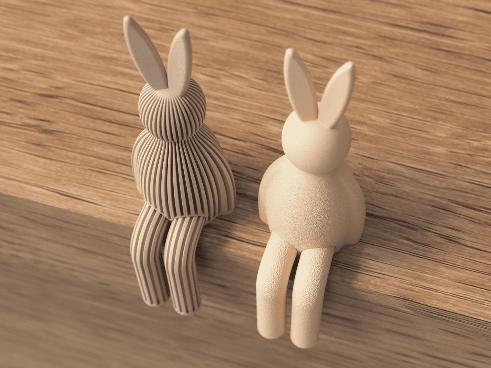 Two rabbit-shaped decorative items, one striped and one plain, on a wooden surface.