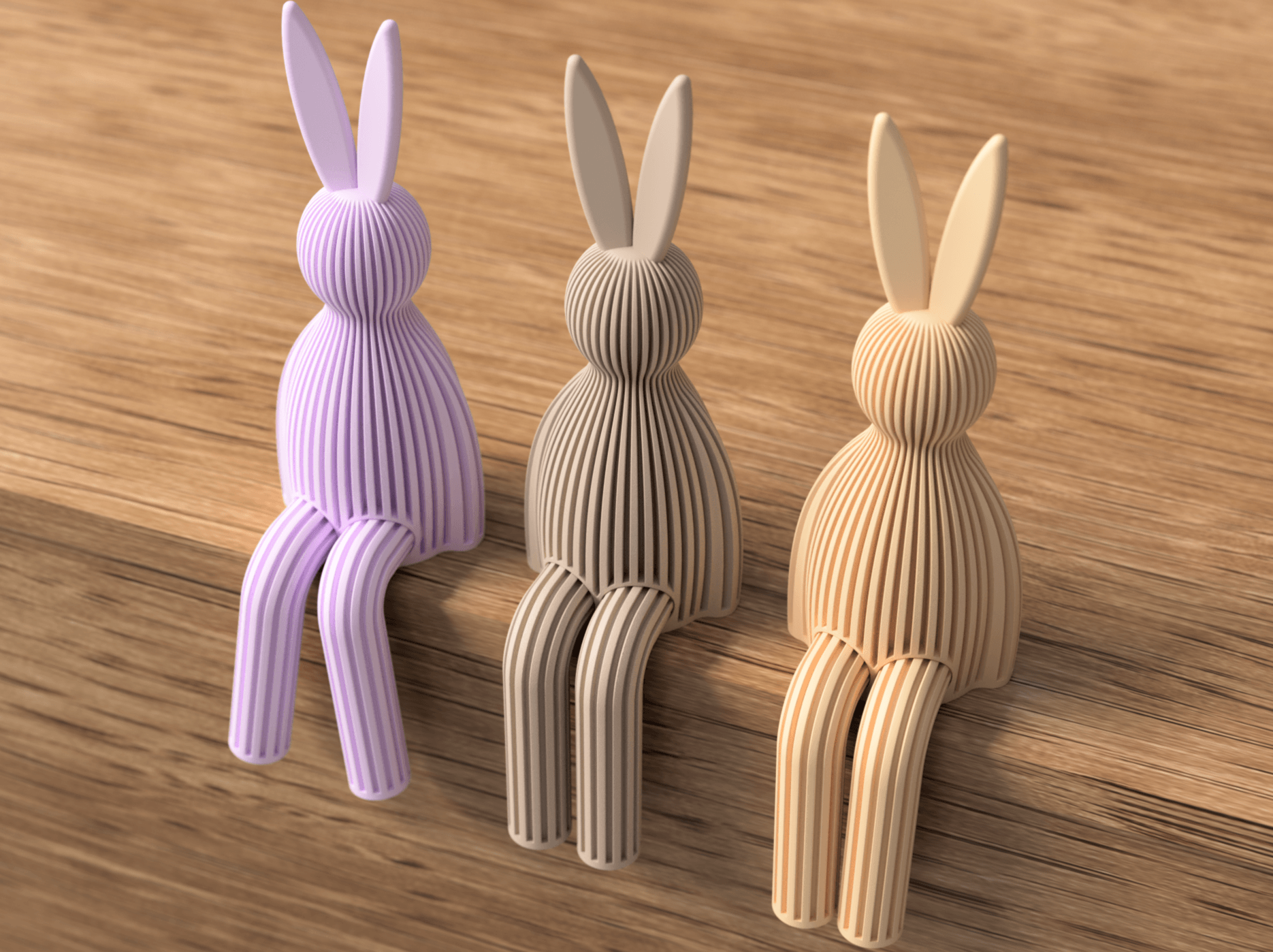 Three rabbit-shaped desk holders in purple, beige, and brown on a wooden surface.
